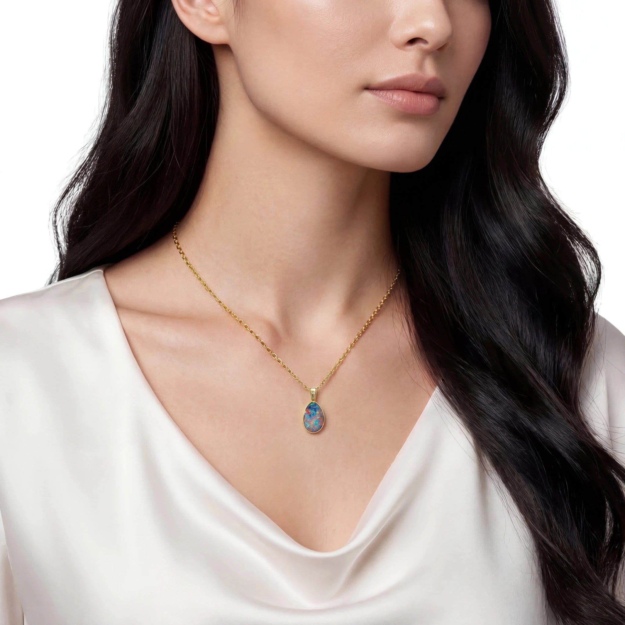 Woman wearing a gold necklace with a colourful pendant on a white background