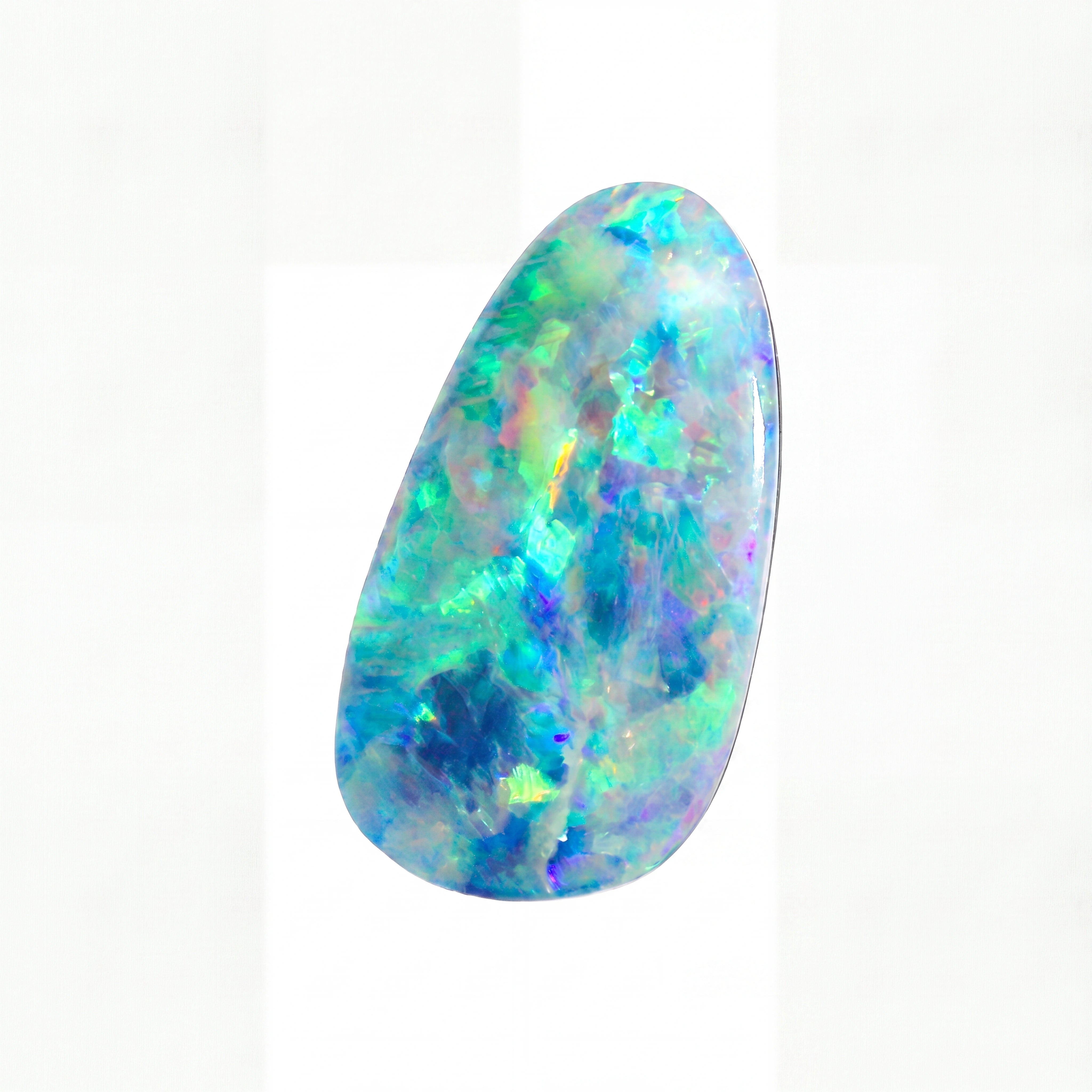 A polished teardrop-shaped cabochon opal gemstone displaying vibrant iridescent flashes of blue, green, purple, and yellow on a white background.