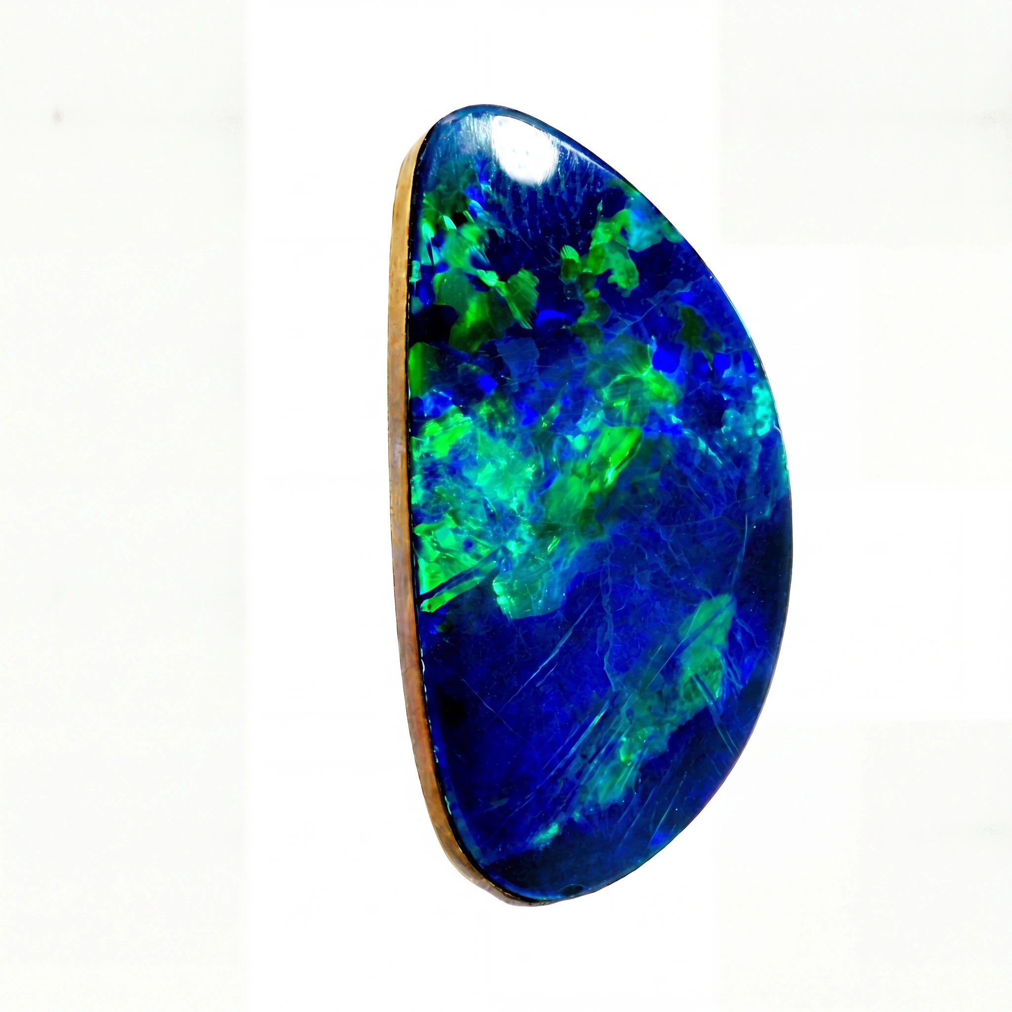 A polished teardrop-shaped opal gemstone with vibrant blue and green flashes, set in a gold bezel on a plain white background.