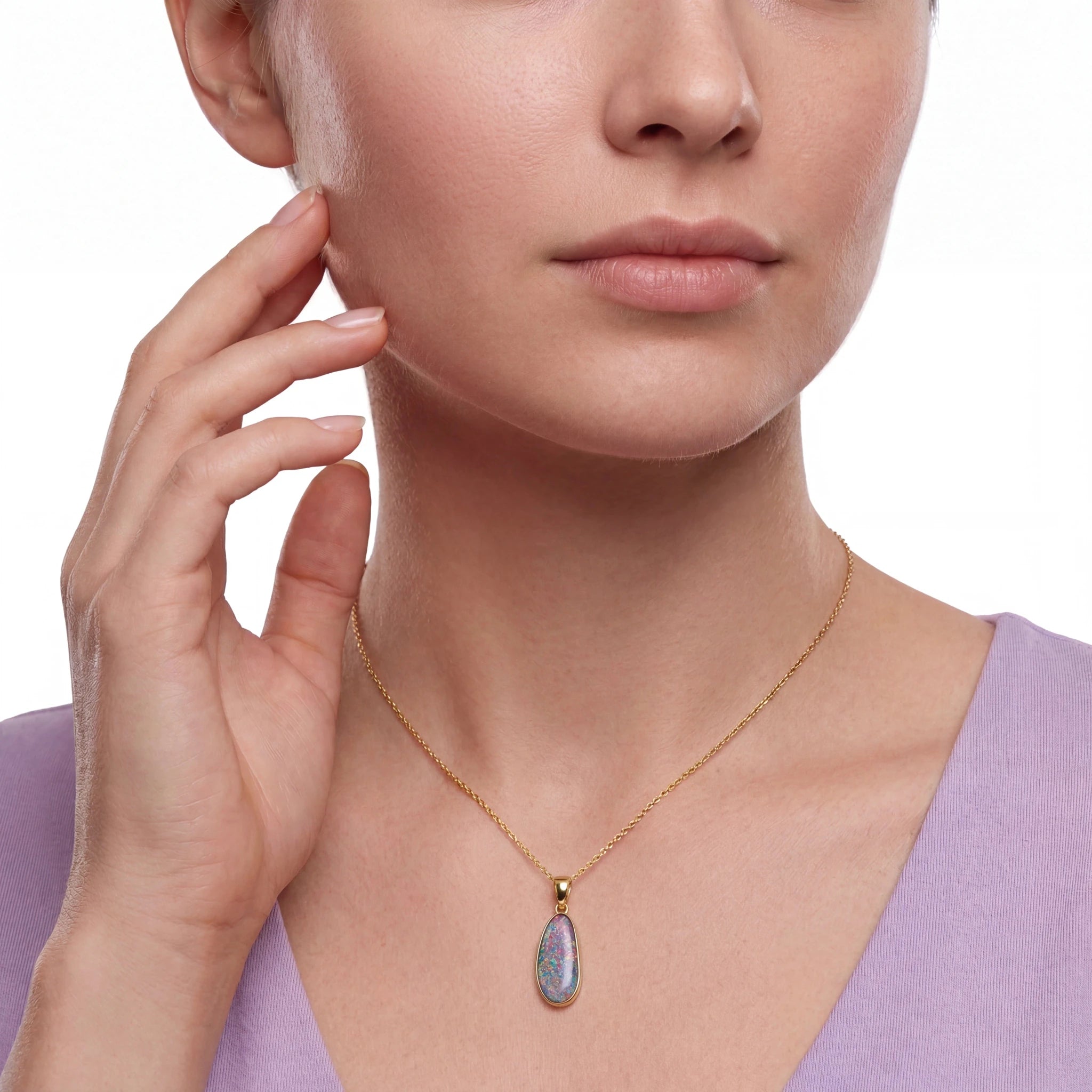 Close-up of a woman wearing a gold necklace with a pendant on a white background