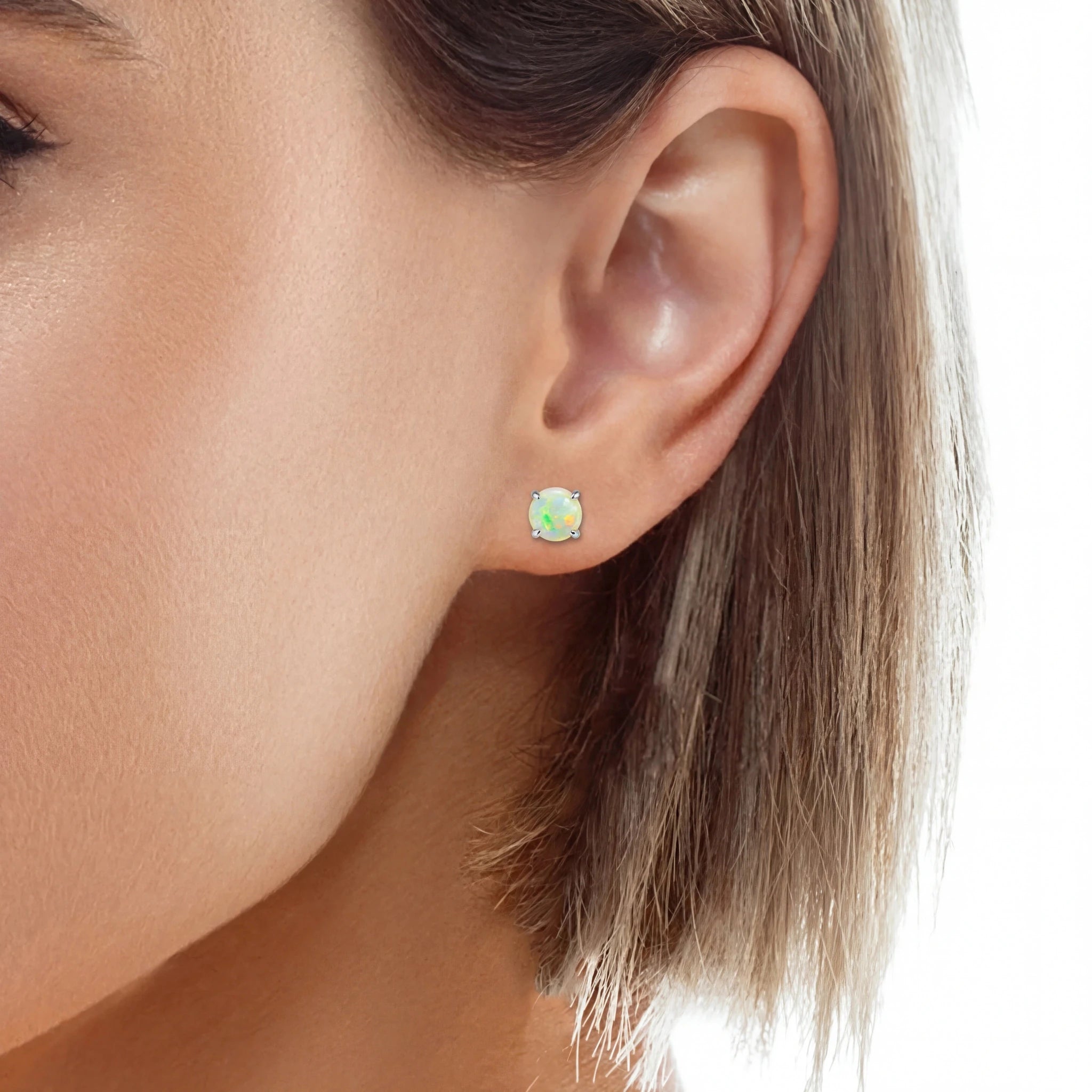 Heart-shaped opal earrings worn by a woman