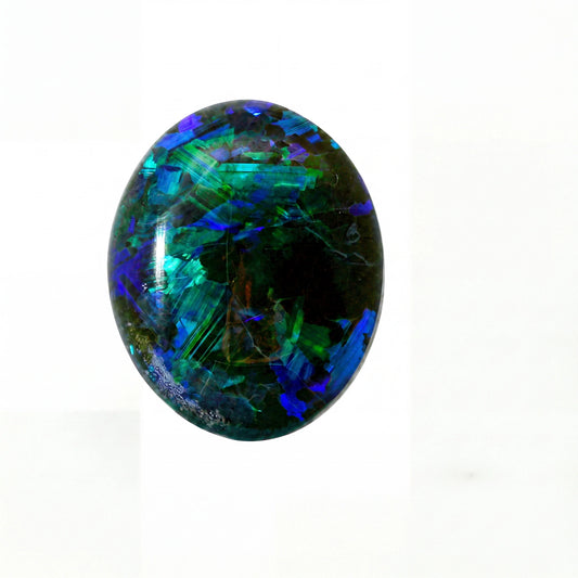 A polished oval cabochon gemstone featuring vibrant iridescent colours including blue, green, and purple over a dark base, set against a plain white background.
