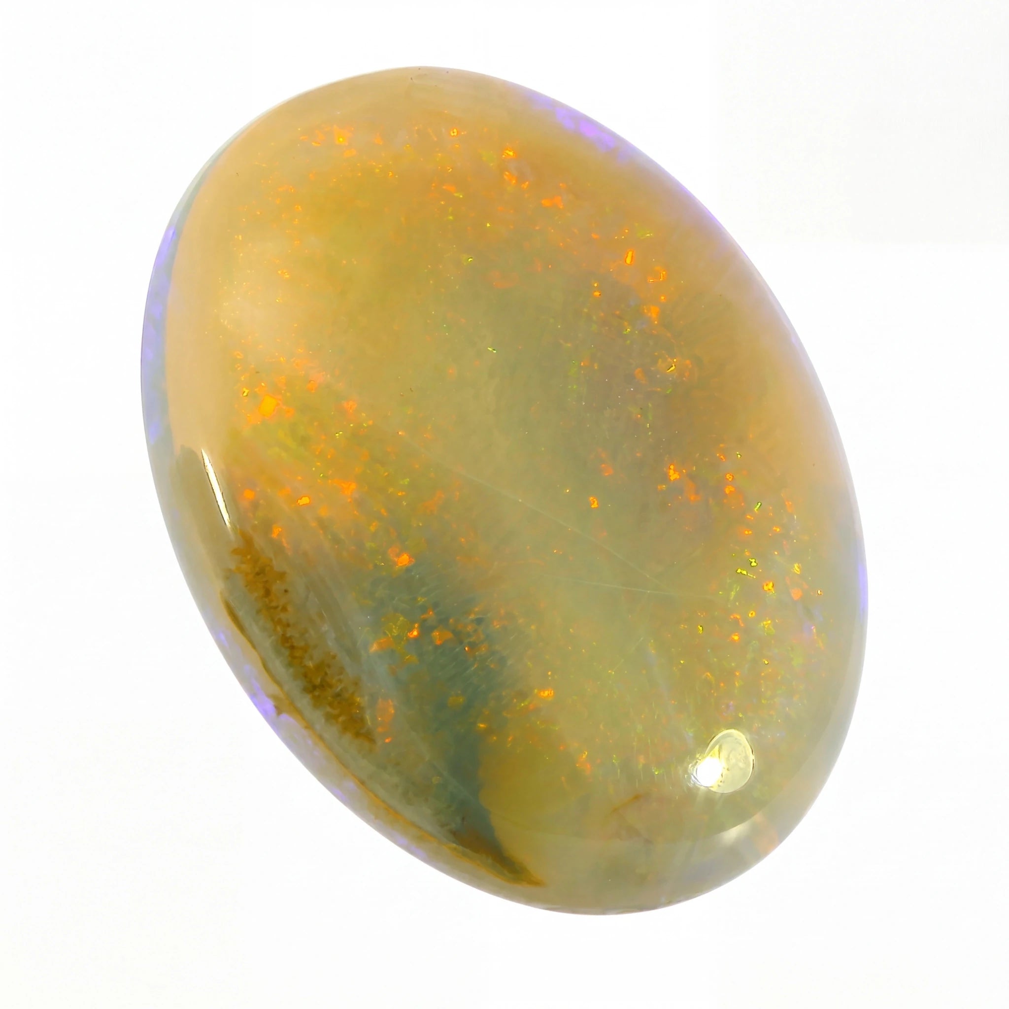 Opal stone with a yellowish hue and speckled pattern on a white background