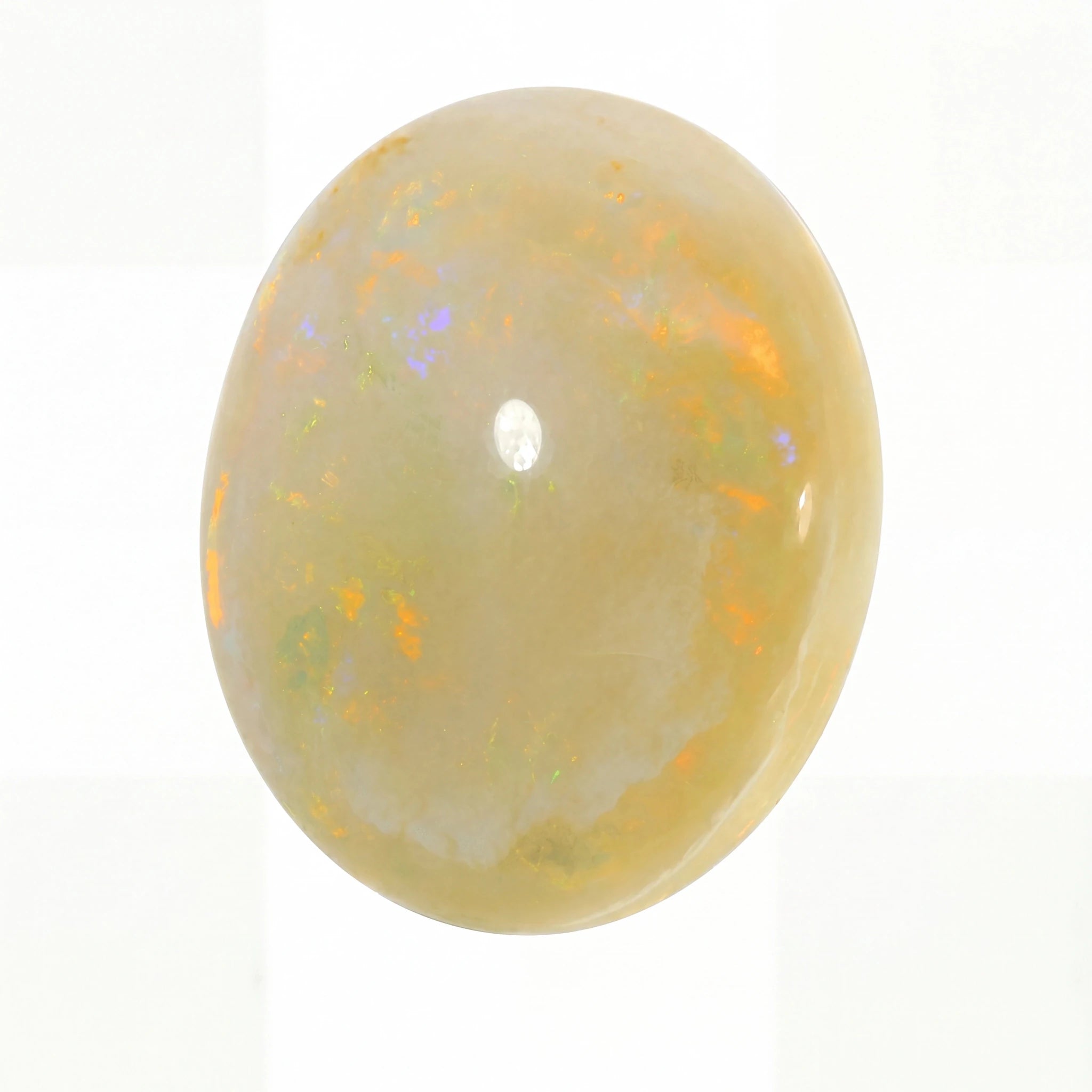Opal stone with colourful play of light on a white background