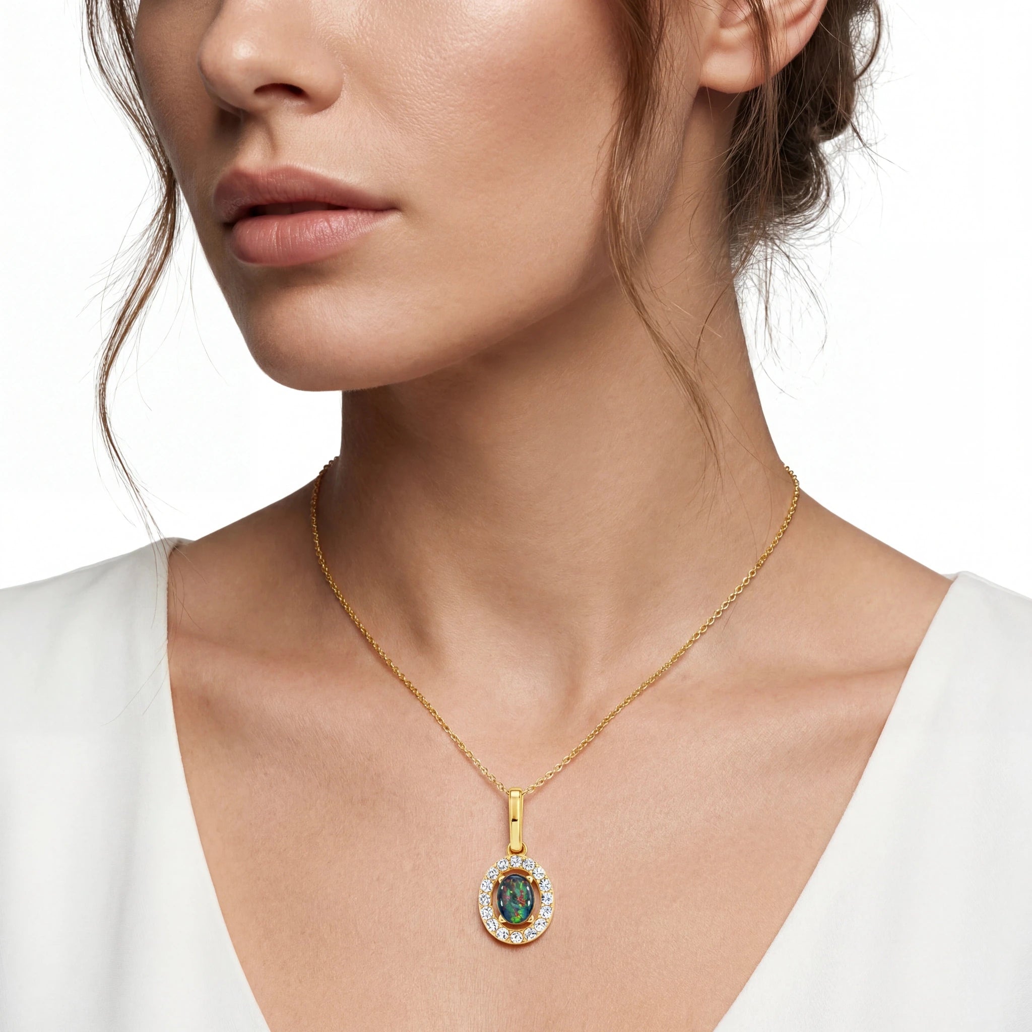 Close-up of a woman wearing a gold necklace with a pendant on a white background