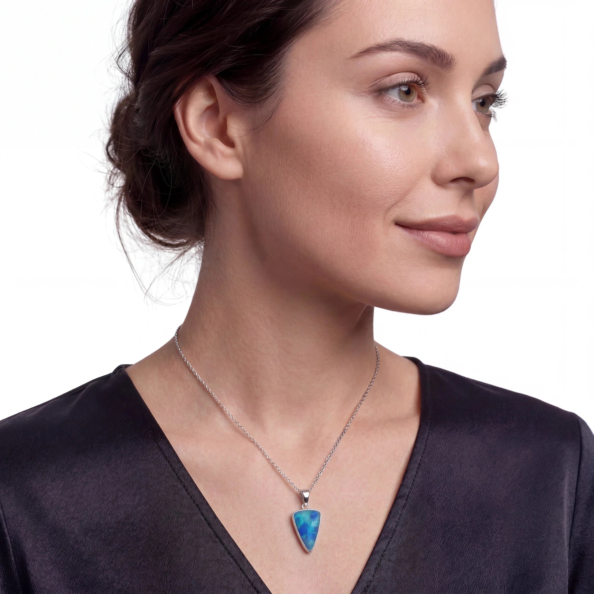Woman wearing a necklace with a blue pendant on a white background