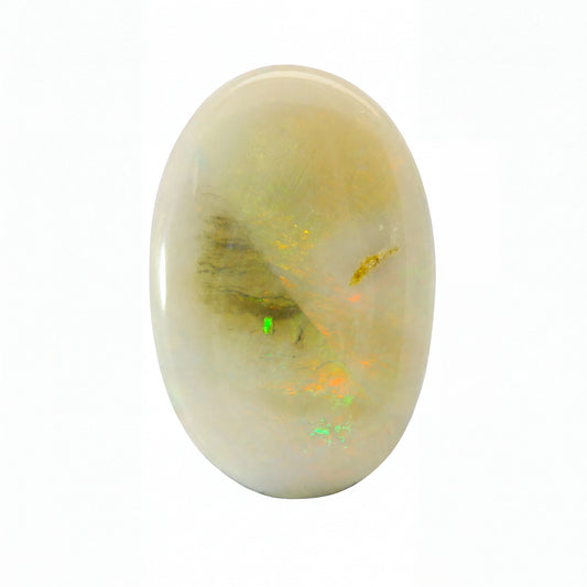 A polished oval cabochon gemstone featuring a creamy off-white base with internal inclusions of dark brown, gold, and vibrant flashes of green and orange, set against a plain white background.