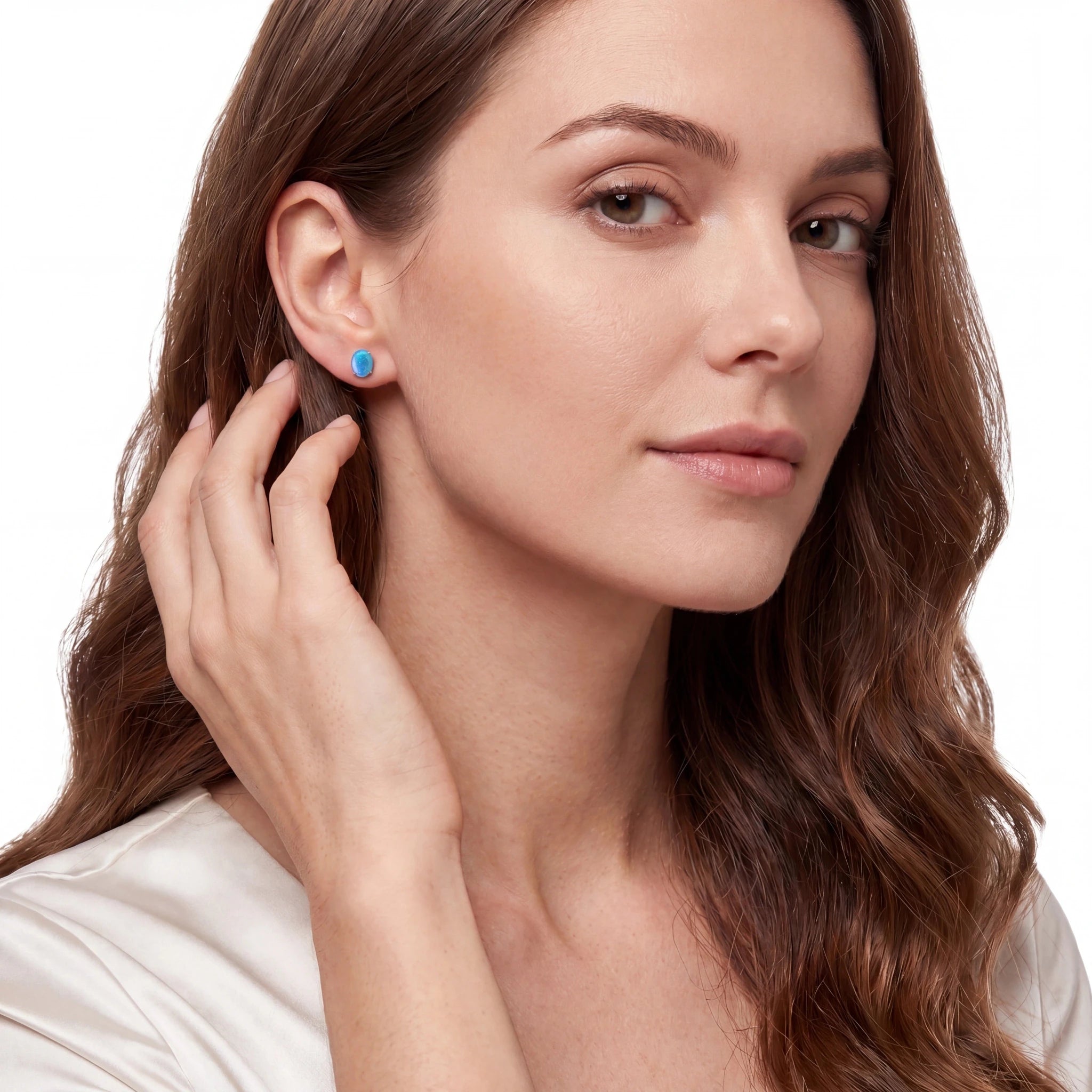 Woman wearing blue earrings on a white background