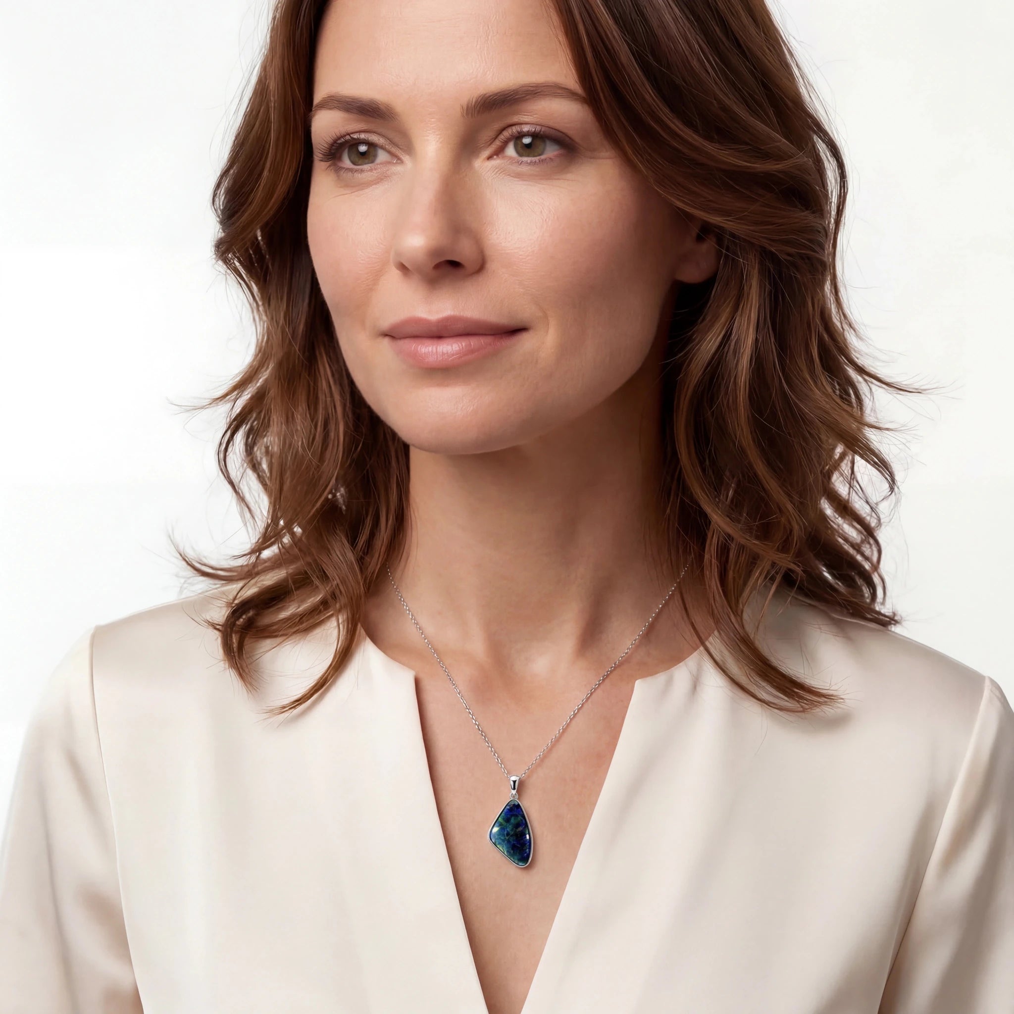 Woman wearing a necklace with a blue pendant on a white background