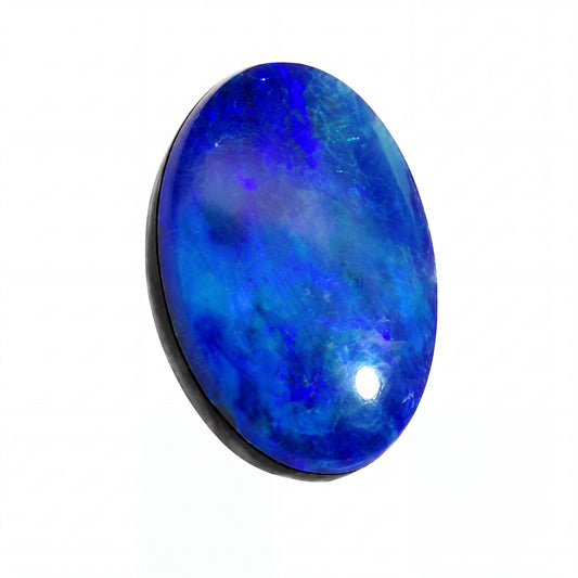 A polished oval cabochon gemstone with a marbled blue and violet pattern, set in a black bezel on a plain white background.