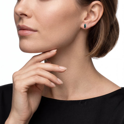 Close-up of a woman wearing a green opal gemstone earring on a white background