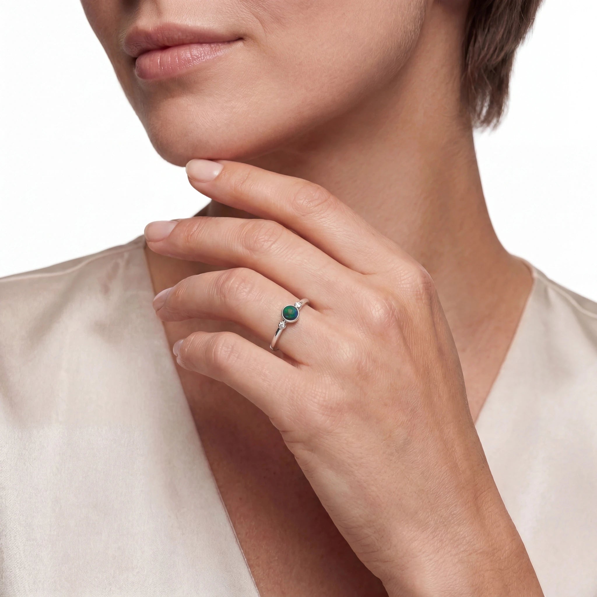 Close-up of a woman hand wearing a ring with a green opal gemstone