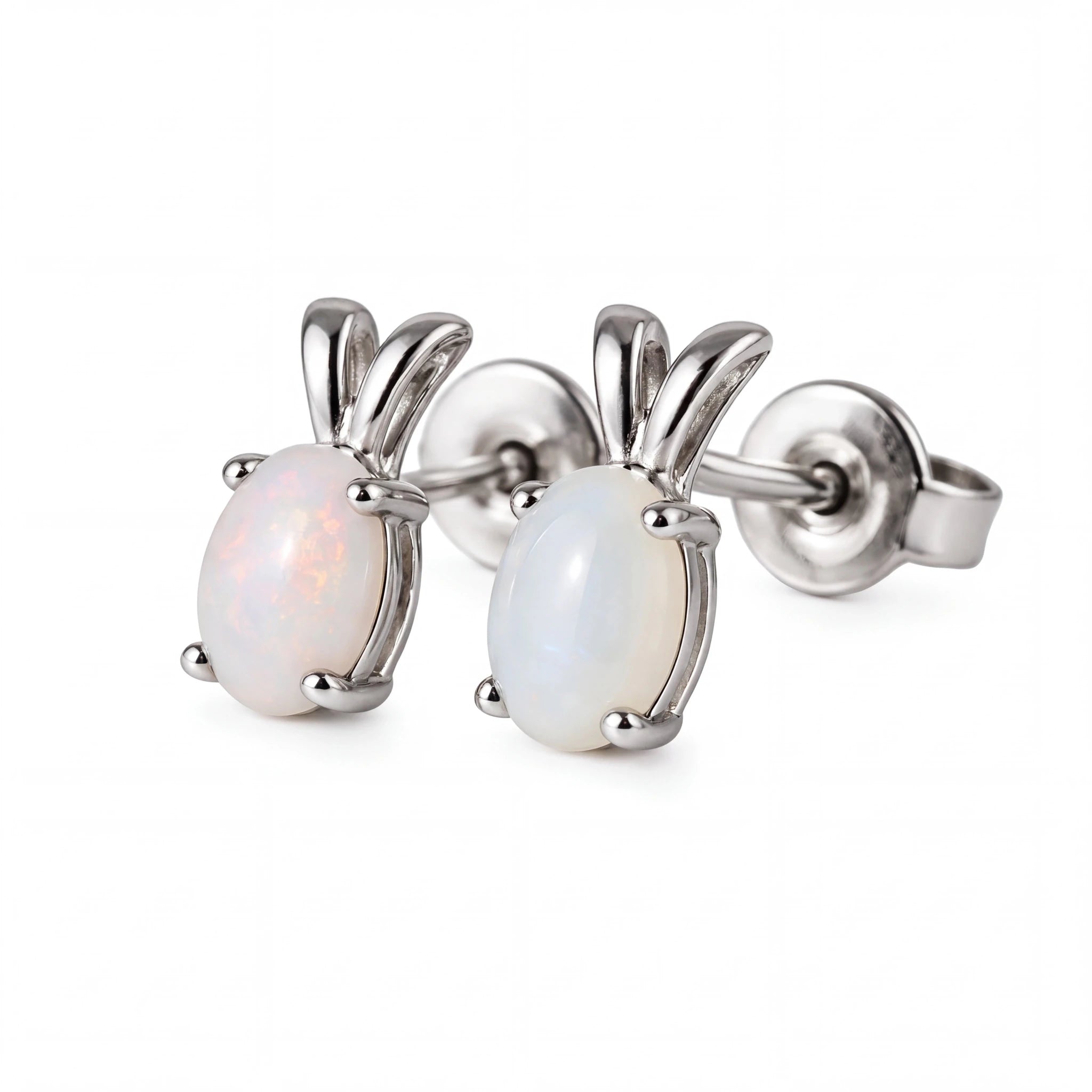 A pair of silver stud earrings featuring oval white opal gemstones in a prong setting with curved silver metal tops, shown on a plain white background.