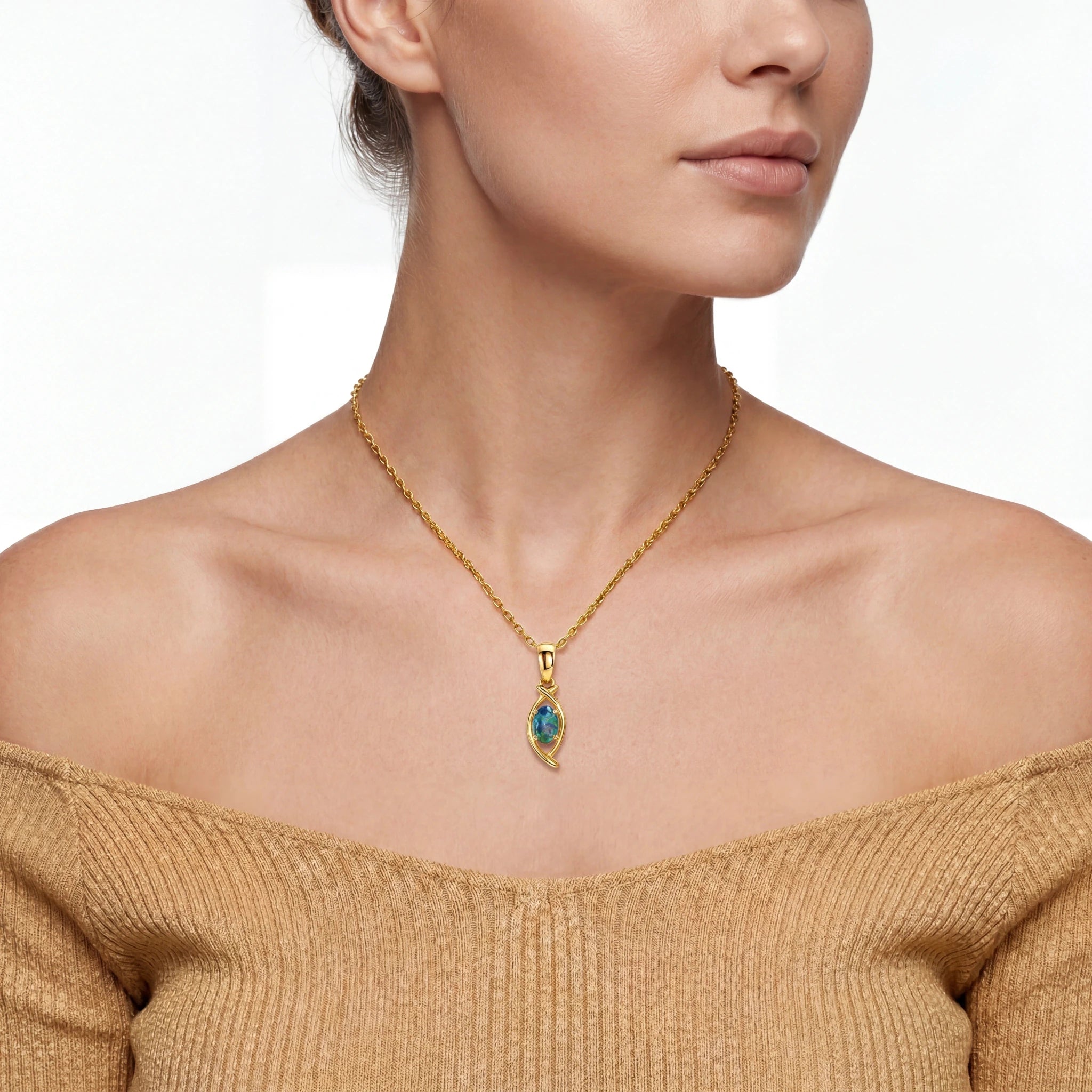 Woman wearing a gold necklace with a blue gemstone pendant on a white background
