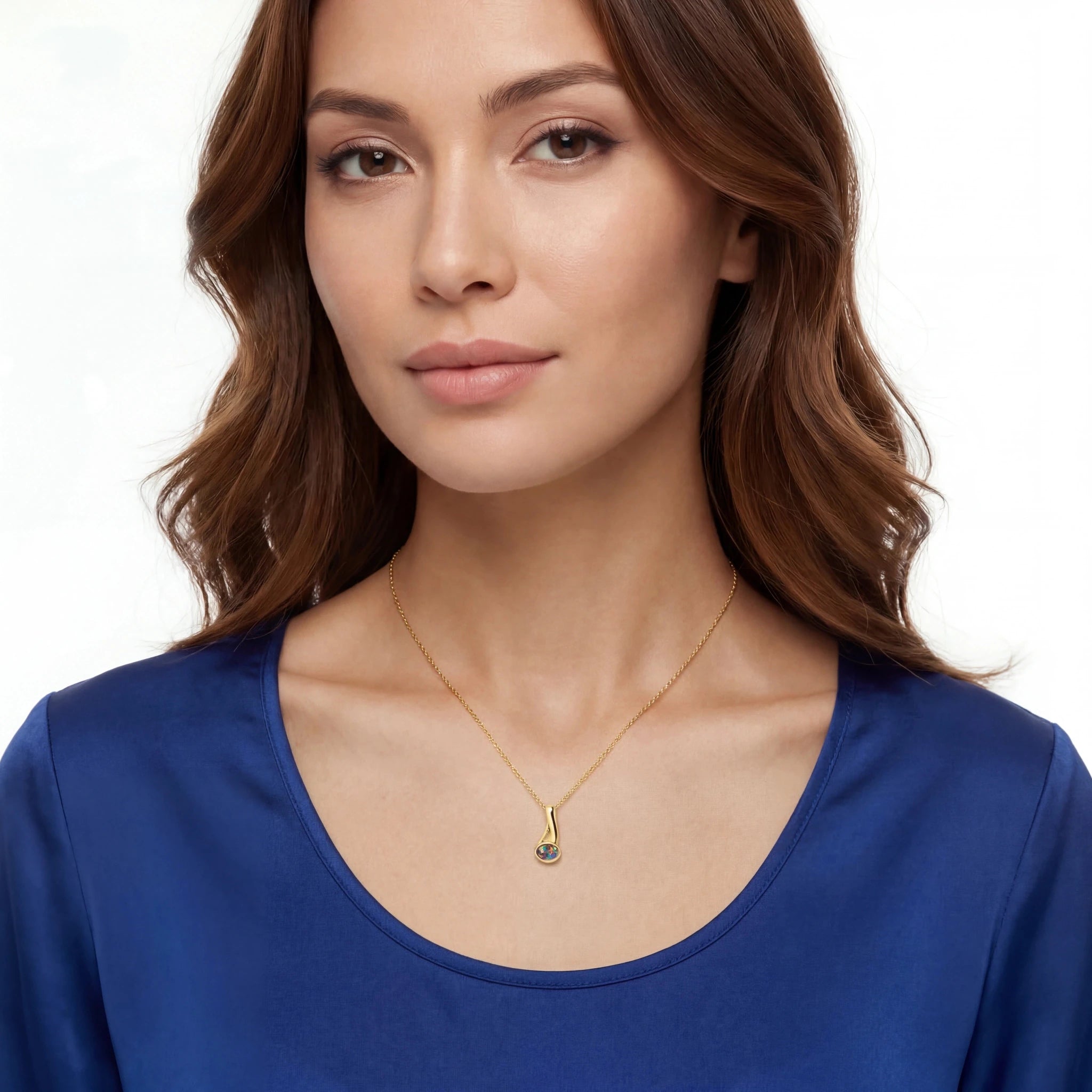 Woman wearing a gold opal necklace with a blue top on a white background