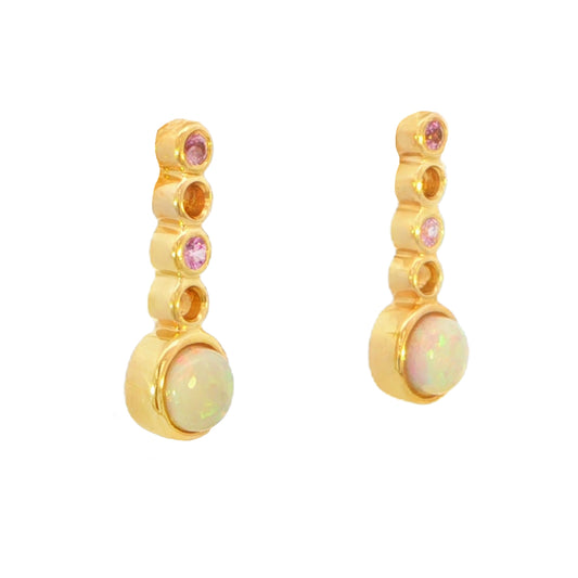 A pair of gold drop earrings featuring a vertical column of five bezel-set round stones, including two small pink stones and one larger iridescent white opal-like stone at the bottom.