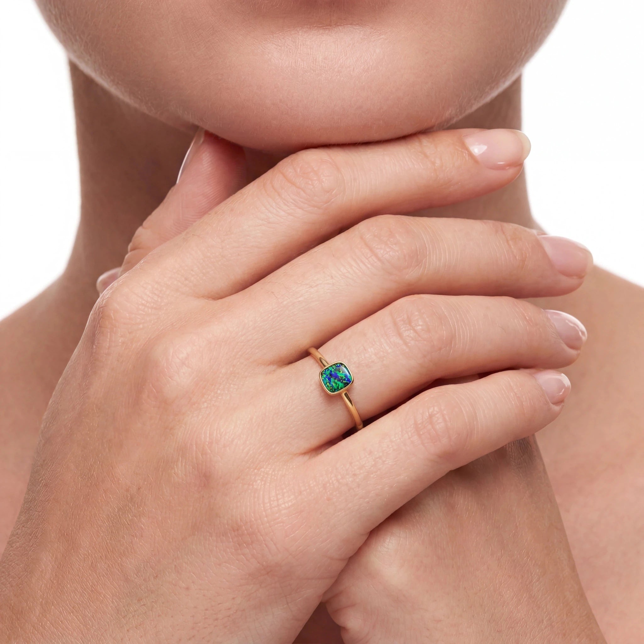 Woman wearing a gold ring with an opal stone