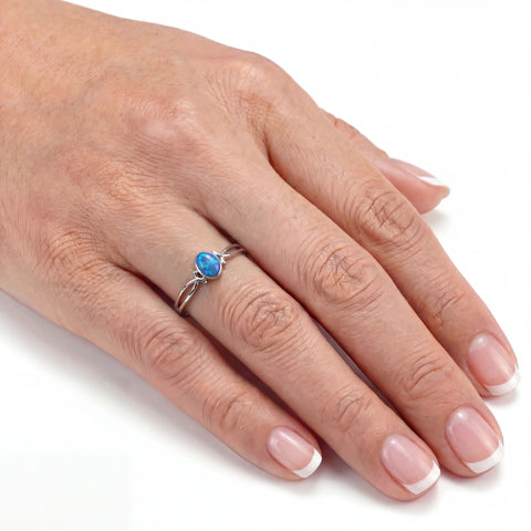 Hand wearing a ring with a blue gemstone on a white background
