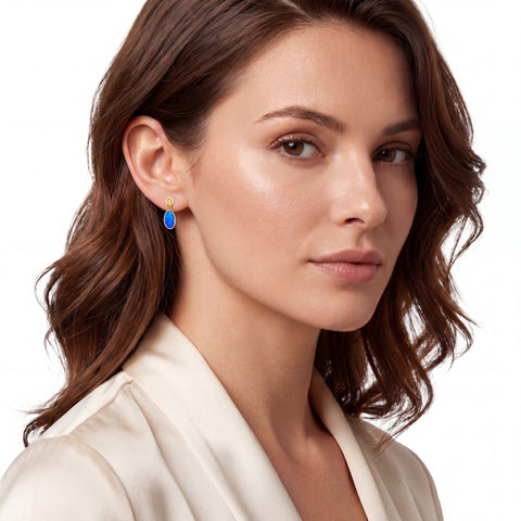 Close-up of a woman wearing a blue earring on a white background