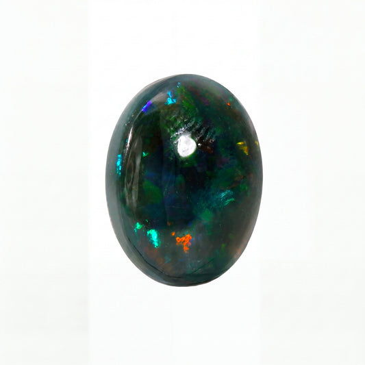 A polished oval cabochon gemstone, likely an opal, displaying a dark black base with vibrant, shifting flashes of green, blue, and orange, set against a plain white background.
