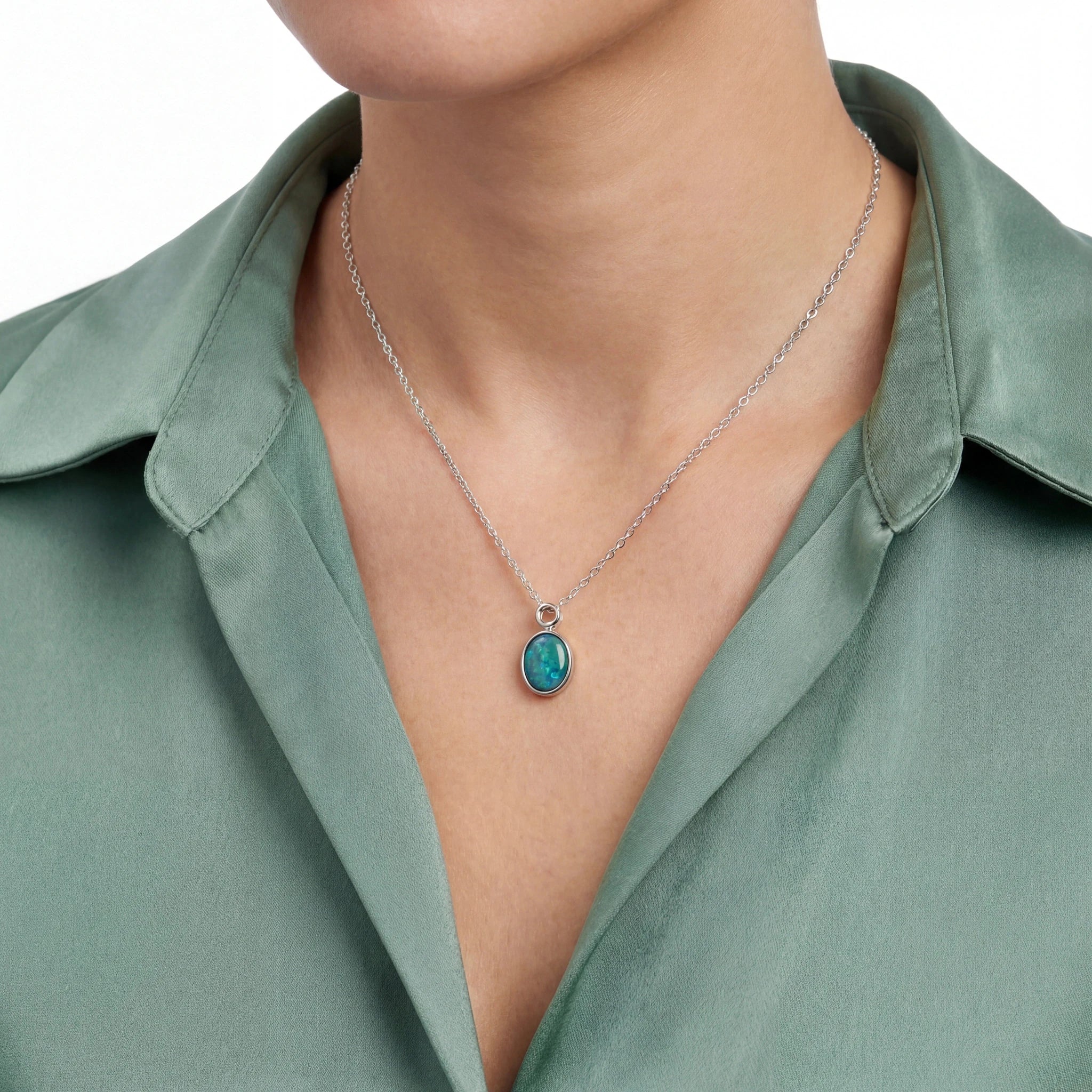 Necklace with a green pendant worn by a person in a green shirt
