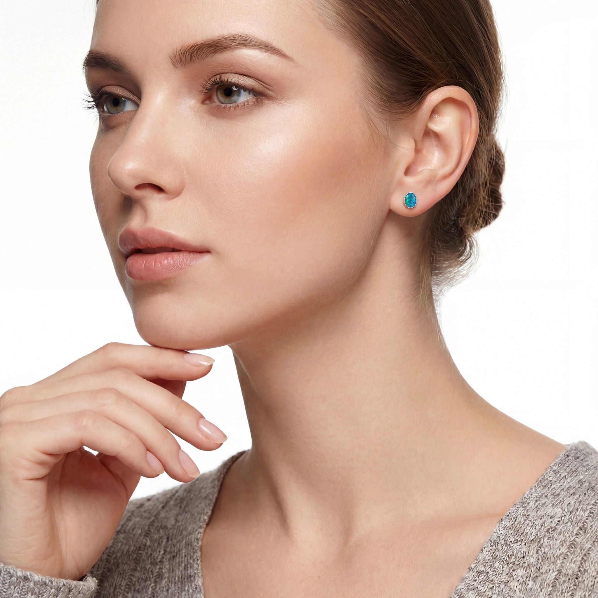 Close-up of a woman wearing turquoise earrings on a white background