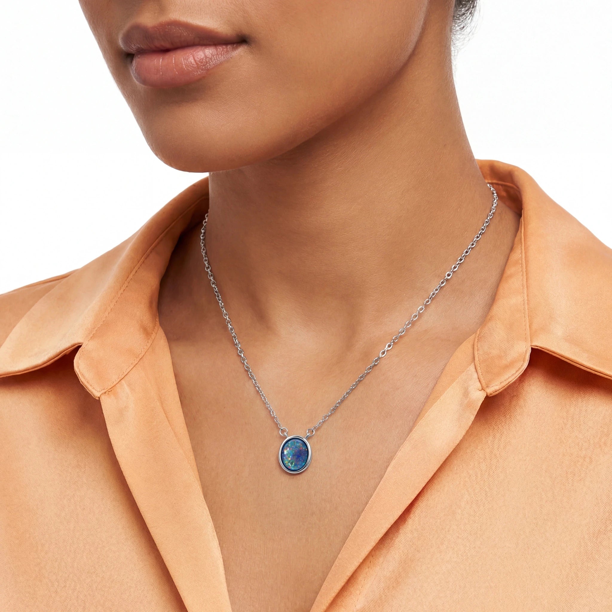 Necklace with an opal pendant worn by a woman against a neutral background