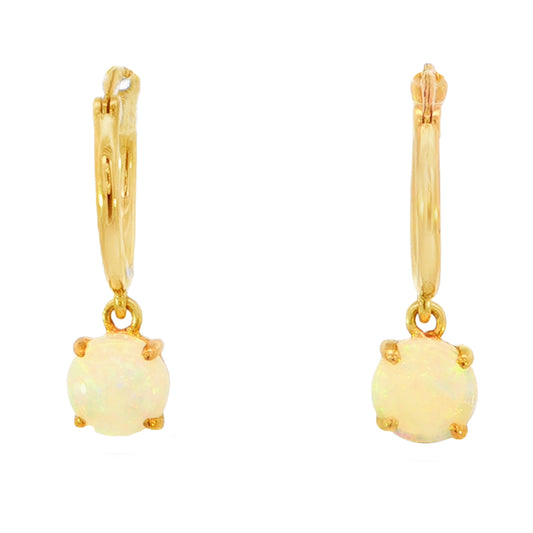 A pair of gold huggie hoop earrings with oval white opal dangles, shown against a plain white background.