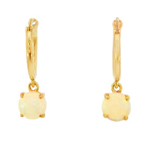 A pair of gold huggie hoop earrings with oval white opal dangles, shown against a plain white background.