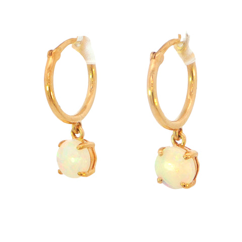 A pair of gold huggie hoop earrings with dangling round white opal gemstones in a four-prong setting, shown on a plain white background.