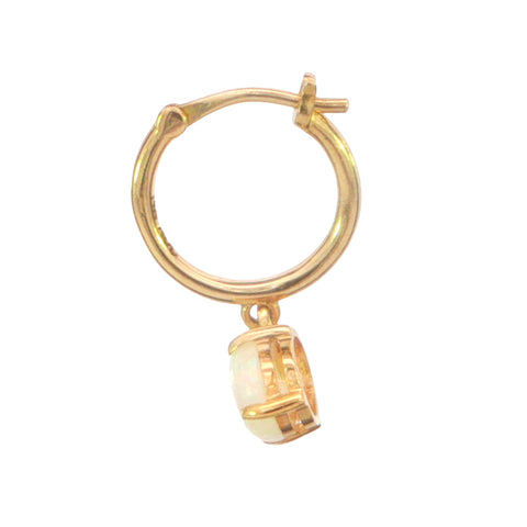 A small gold hoop earring with a dangling cylindrical charm featuring a white inlay or stone, shown on a plain white background.