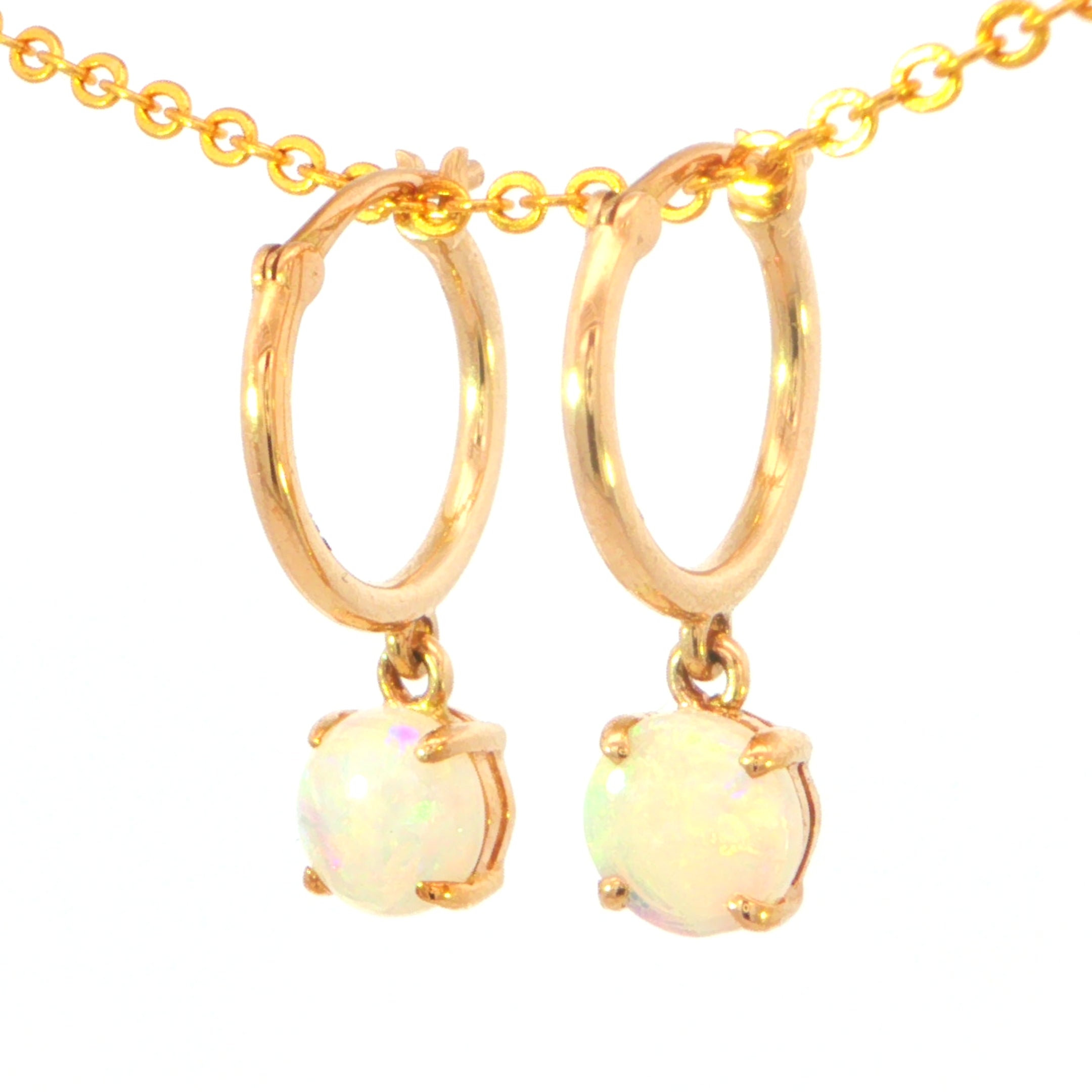 A pair of gold hoop drop earrings with round iridescent opal gemstones, suspended from a gold chain against a plain white background.
