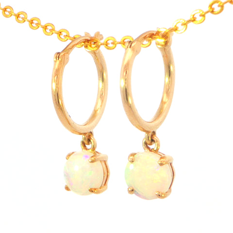 A pair of gold hoop drop earrings with round iridescent opal gemstones, suspended from a gold chain against a plain white background.