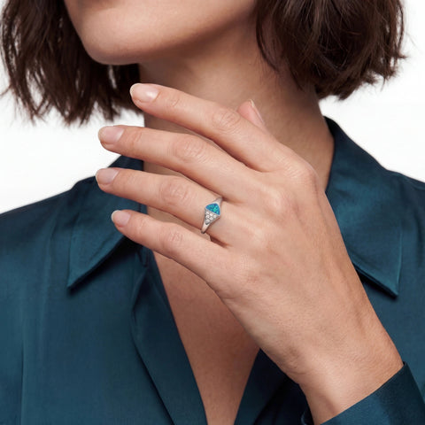 Close-up of a woman hand wearing a ring with a blue opal gemstone