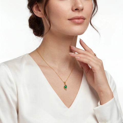 Woman wearing a gold necklace with a green pendant on a white background