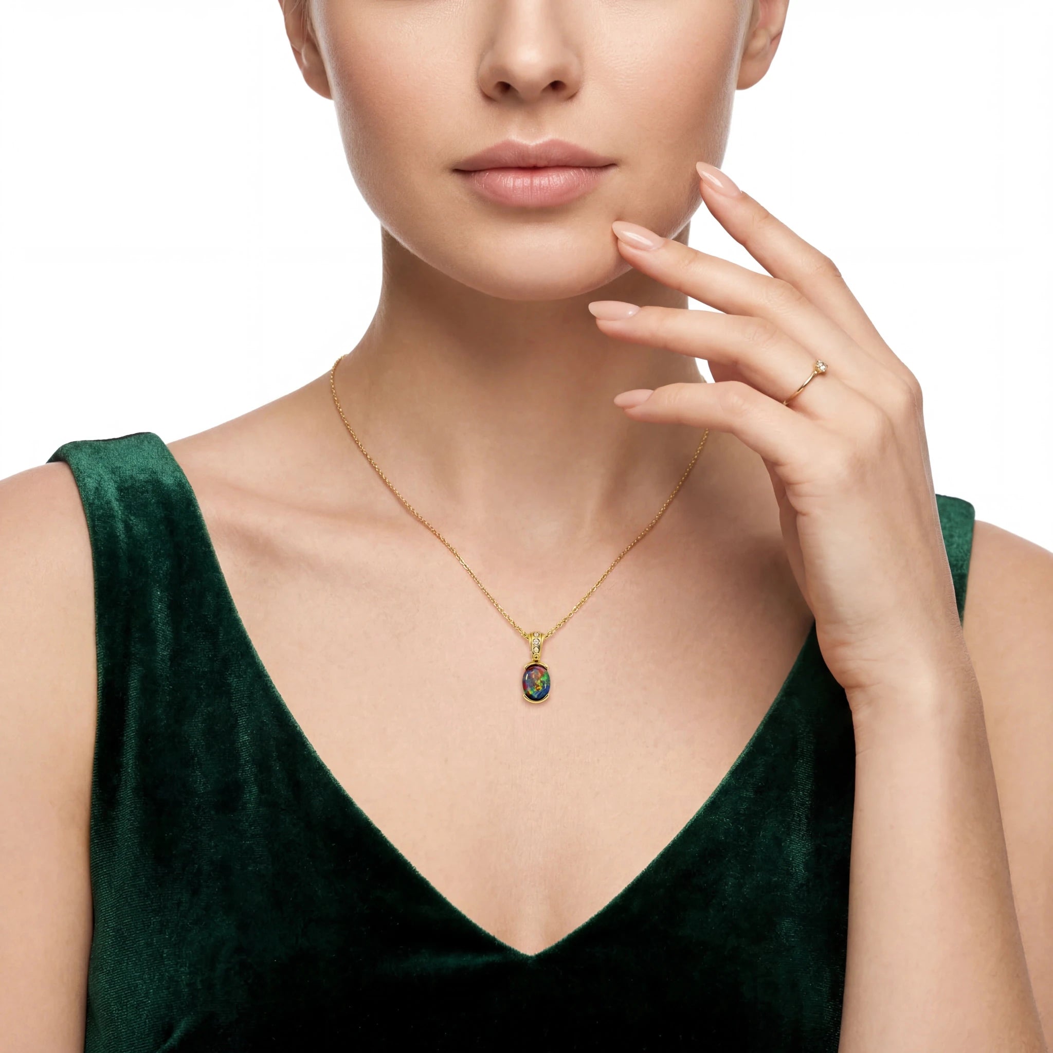 Woman wearing a gold necklace with a green pendant on a white background