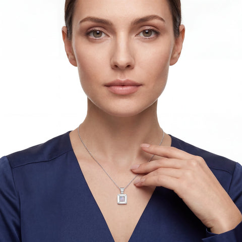 Woman wearing a necklace with a square pendant on a white background