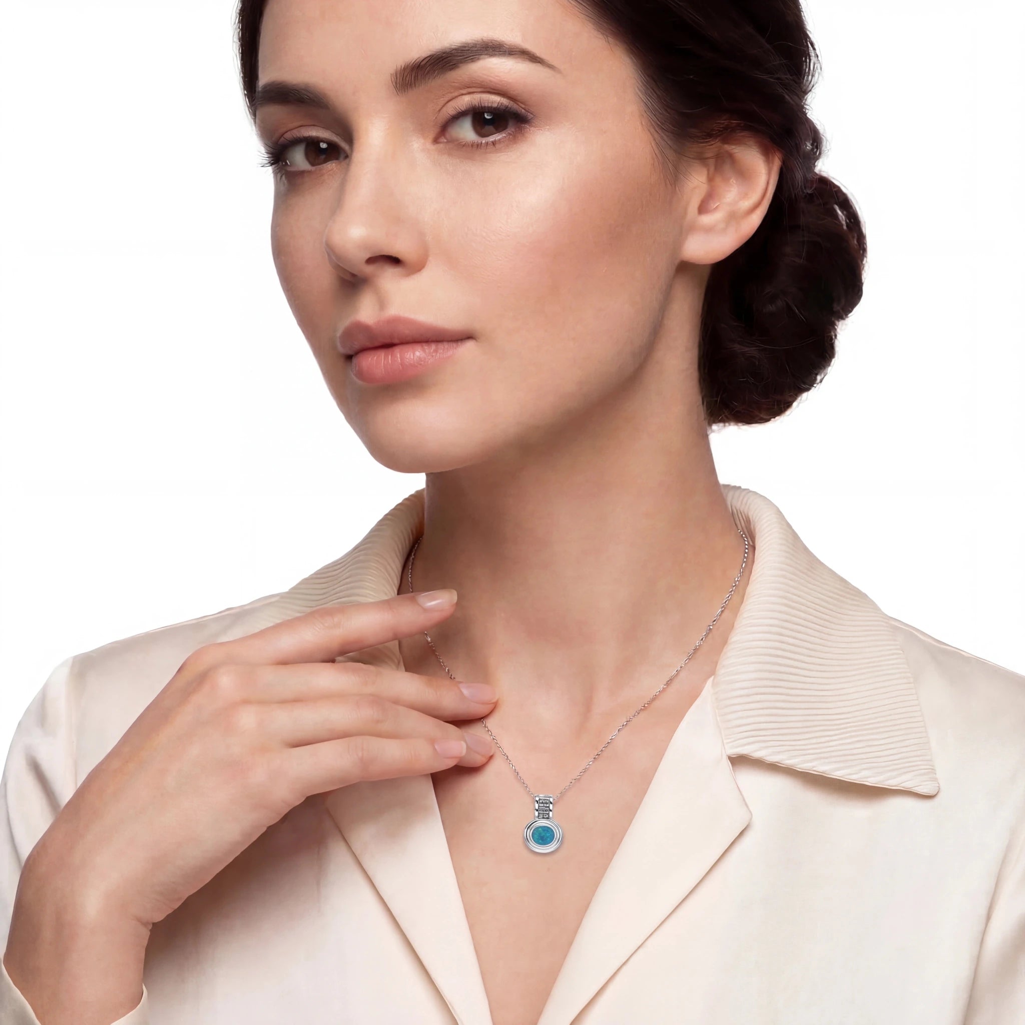 Woman wearing a necklace with a blue gemstone on a white background