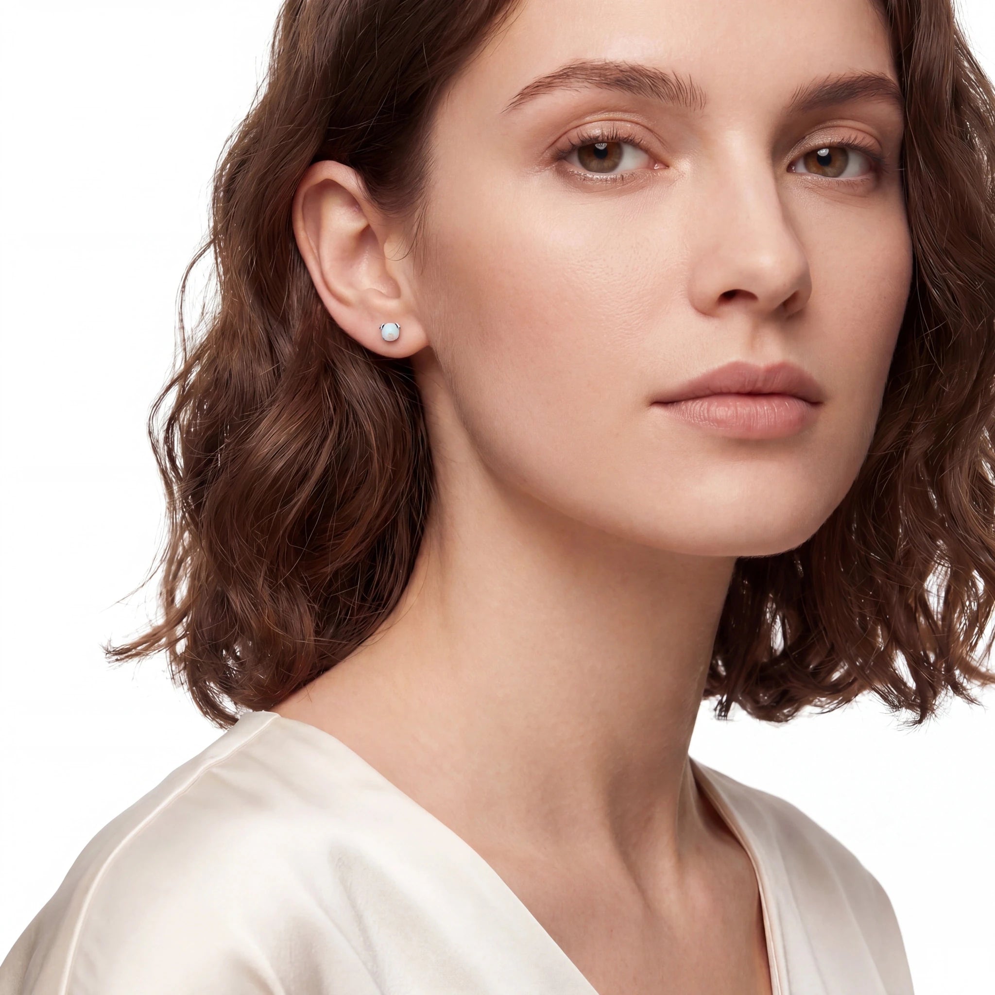 Close-up of a woman wearing a small opal earring