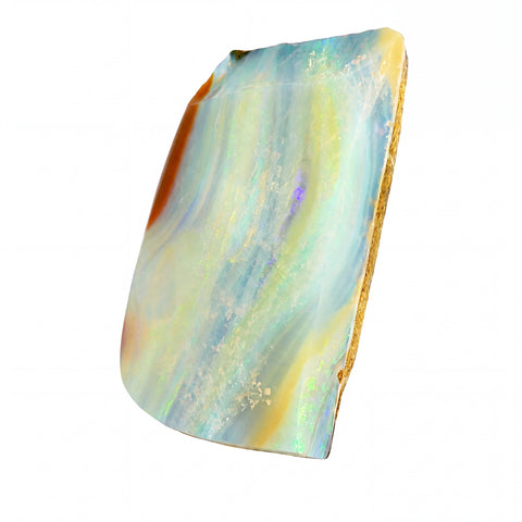 A raw, polished opal stone slab with iridescent bands of light blue, yellow, green, and orange, showing a natural rough edge, isolated on a white background.