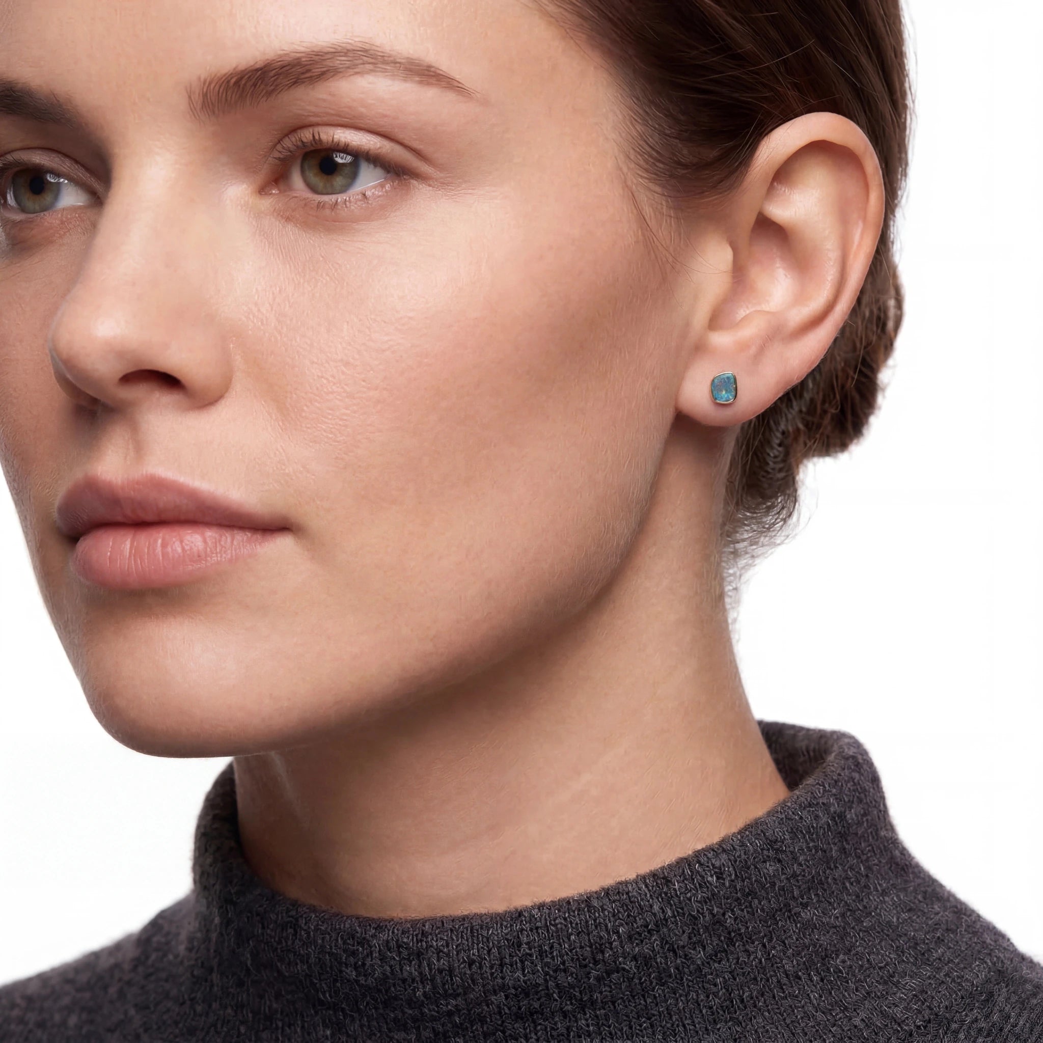 Close-up of a woman wearing a turquoise earring on a white background