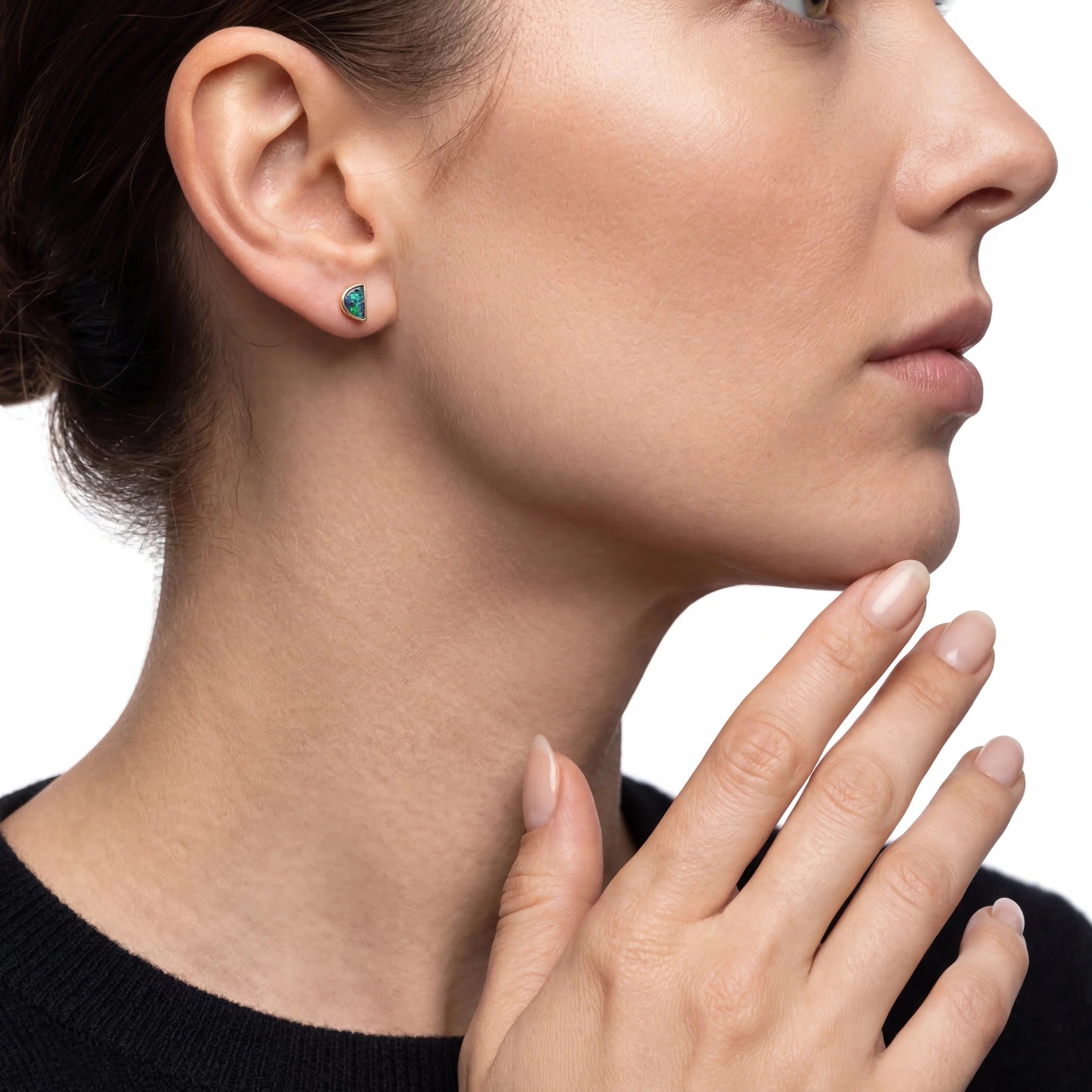 Close-up of a woman wearing a green earring on a white background