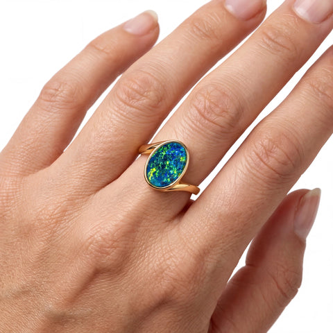 Woman wearing a ring with a colorful gemstone on a white background