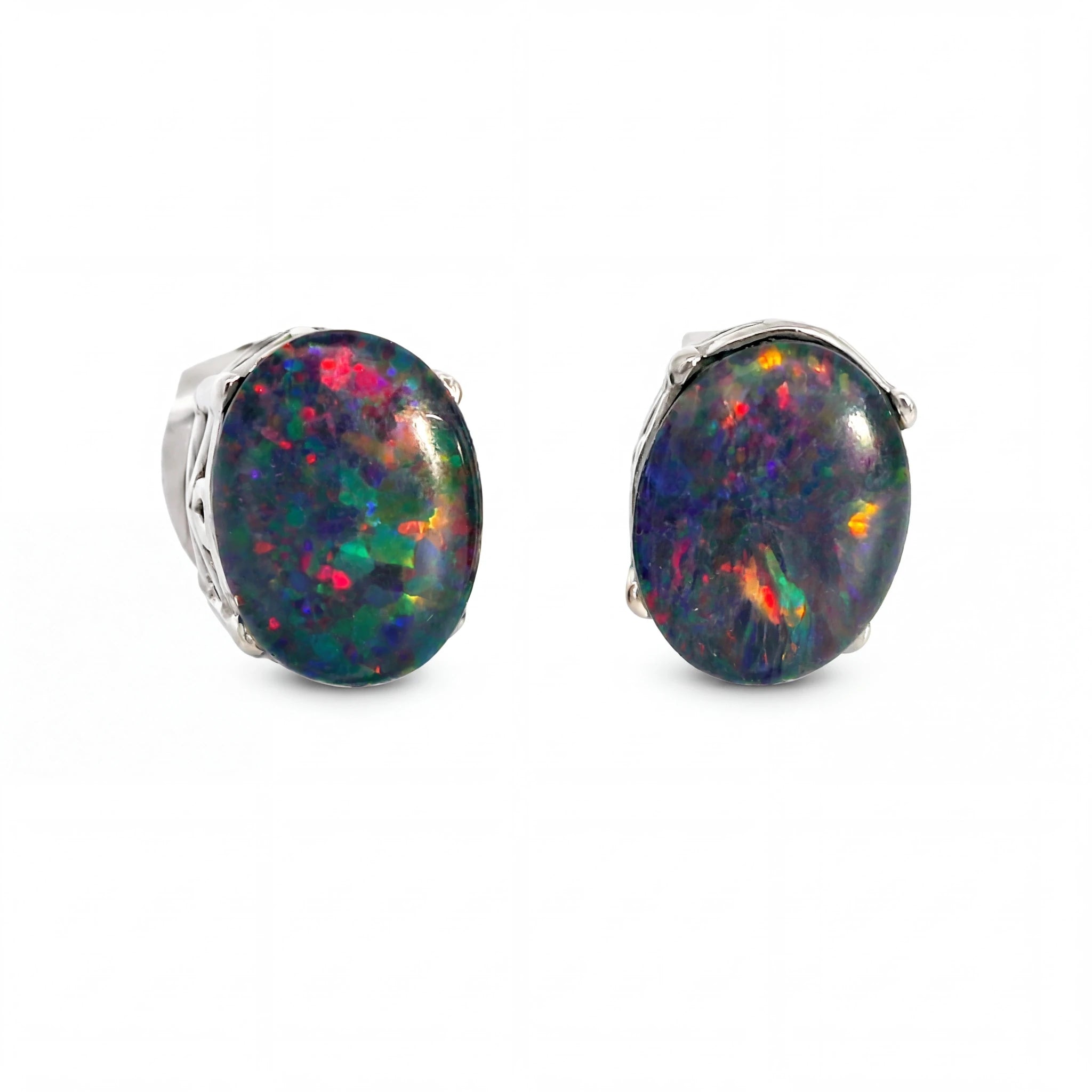 A pair of oval stud earrings featuring vibrant, multicoloured opal gemstones in silver bezel settings, shown against a plain white background.