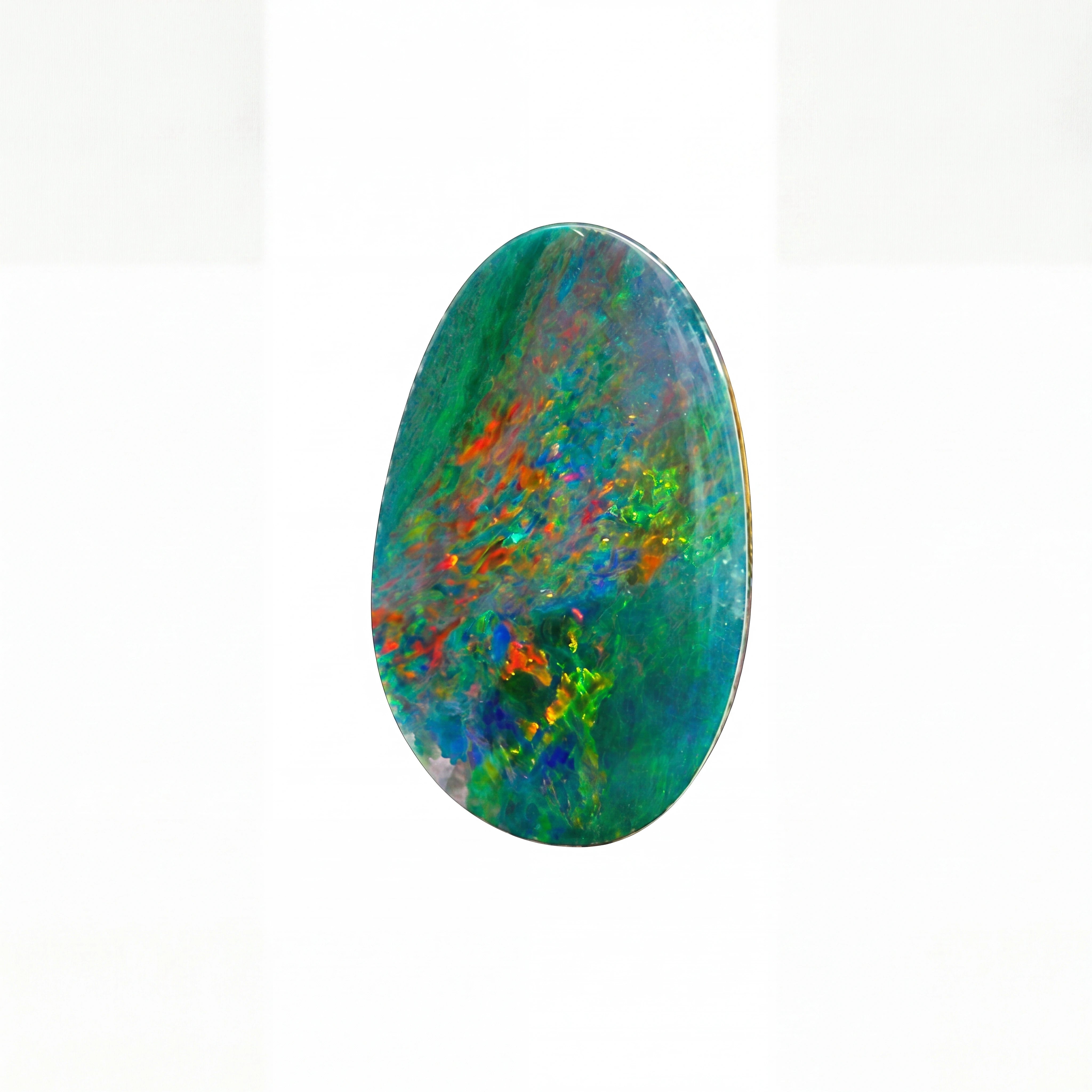 A polished oval cabochon gemstone featuring a vibrant play-of-colour pattern with green, blue, orange, and purple hues, set against a plain white background.