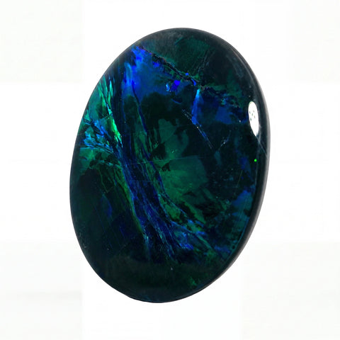 A polished oval cabochon gemstone featuring a deep blue and green opal-like play-of-colour pattern on a white background.