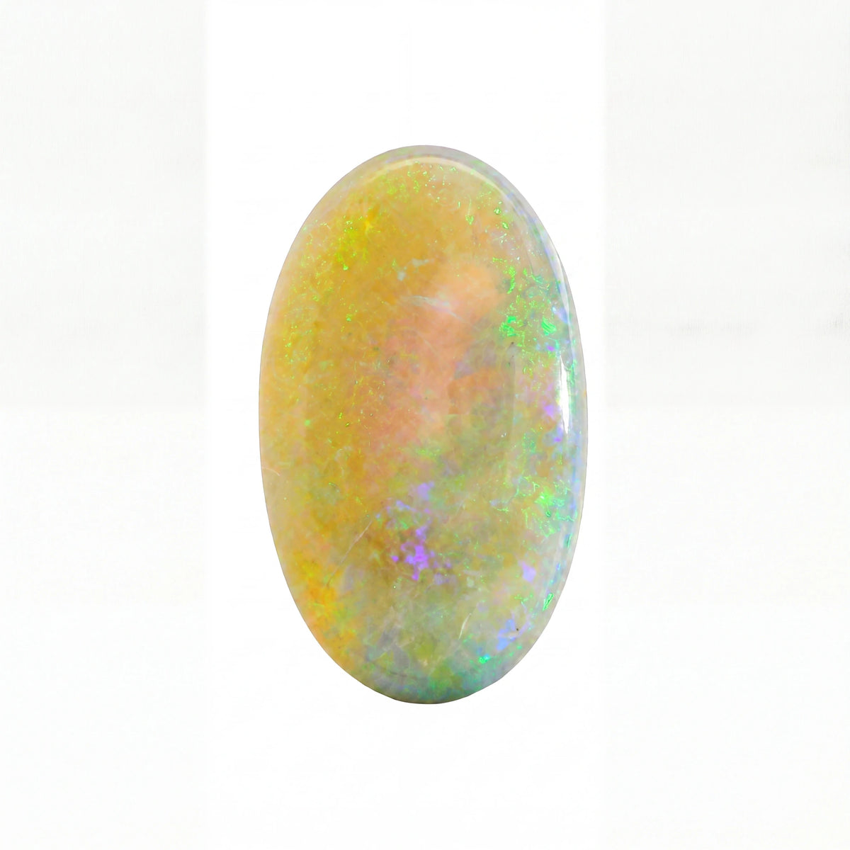 An oval cabochon gemstone showing a play-of-colour opal pattern with vibrant flashes of green, blue, purple, and yellow over a warm peach and cream base, set against a plain white background.