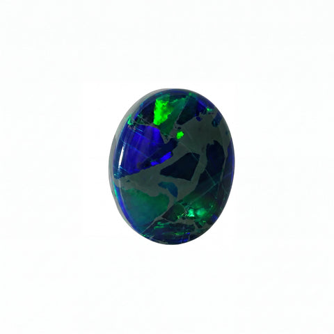 A polished oval cabochon gemstone featuring a vibrant play-of-colour with deep blue, green, and black patterns, set against a plain white background.