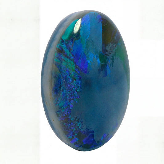 A polished oval cabochon gemstone featuring a deep blue base with vibrant iridescent flashes of green, teal, and purple, set against a plain white background.