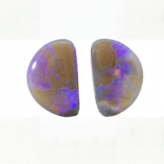 Two polished oval cabochon gemstones showing a mix of brown, purple, and blue iridescent opal patterns on a white background.
